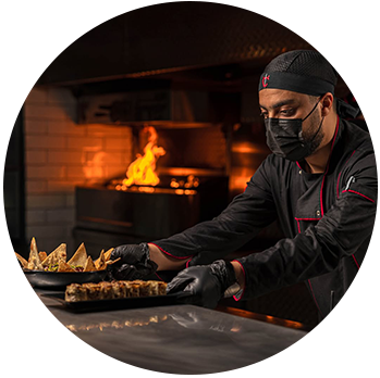 Chef at Carver Steakhouse preparing premium Saudi lamb on the grill in a luxury restaurant in Jeddah