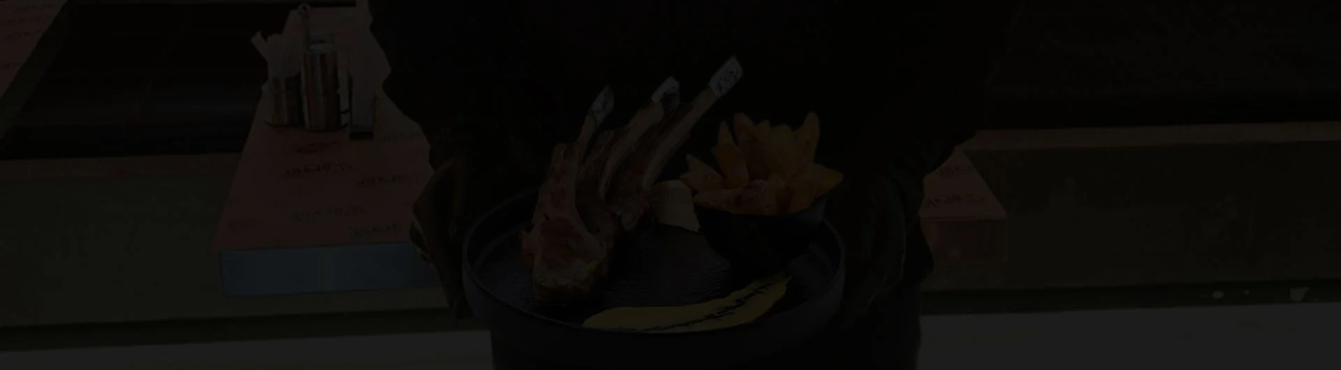 Waiter at Carver Steakhouse serving a premium Saudi lamb dish in a luxury restaurant in Jeddah